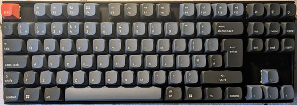 Photograph of the assembled Keychron K8 pro with the UK Windows key setup.  The colours are predominantly a dark blue/grey.